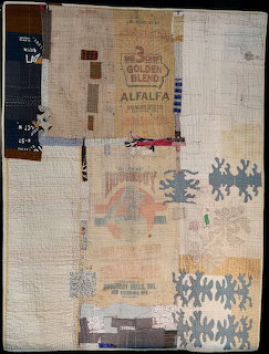 Textile collage with burlap, fabric patches, stitching, and floral appliques in beige and blue tones