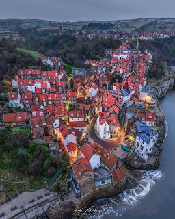 Aerial view of Robin Hood's Bay village with red-roofed houses clustered along the coastline