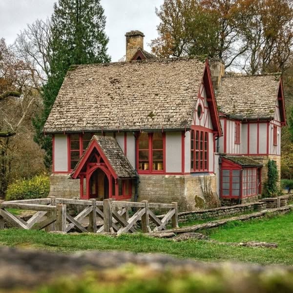 Tudor cottage with red and white timber framing in a countryside setting with autumn trees