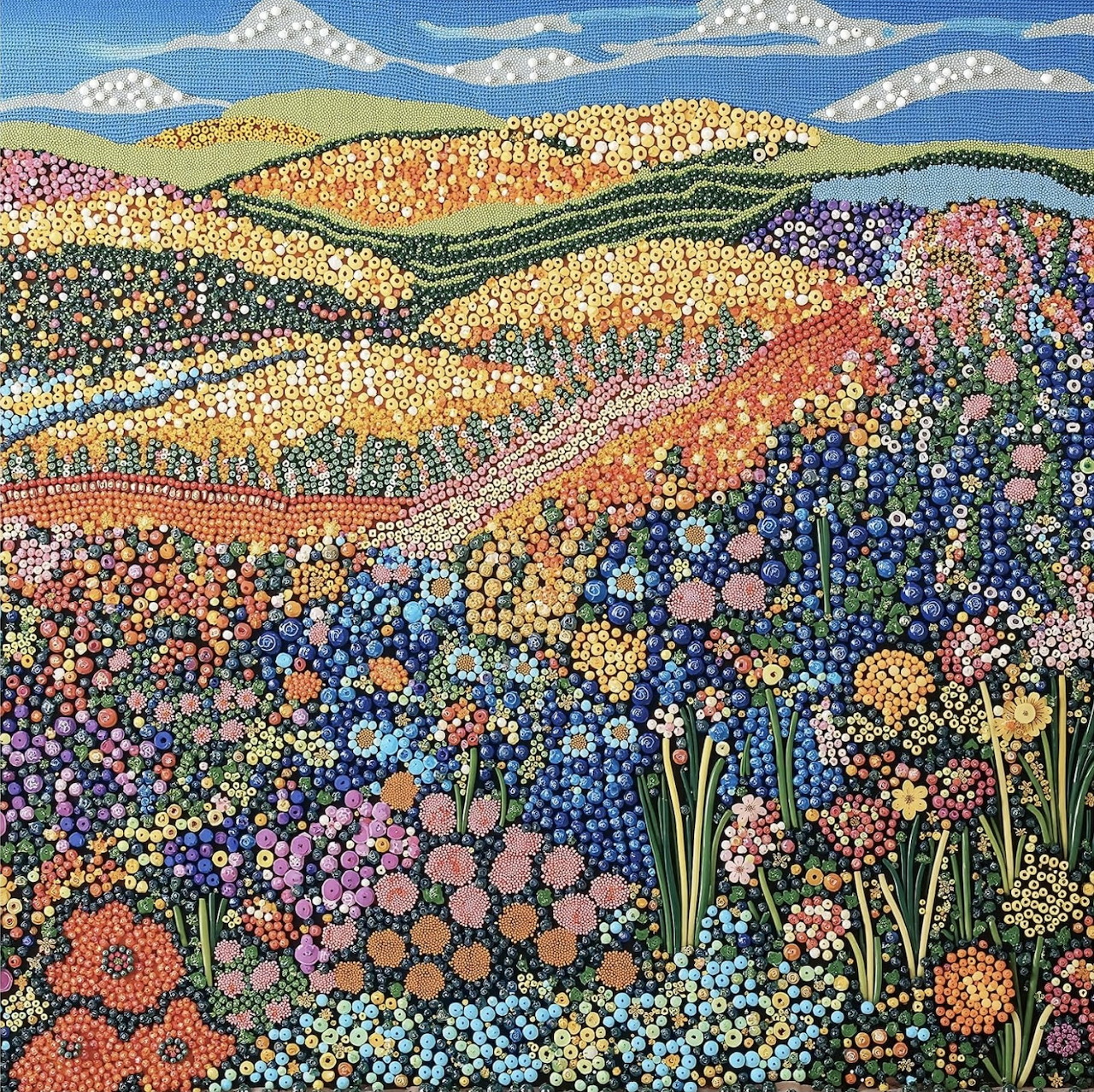 Mosaic art of colorful flower fields rolling across hills beneath mountains and blue sky