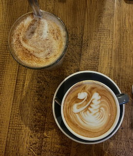 Coffee cup with swan-shaped latte art on a cafe table