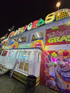 Colorful Mardi Gras carnival funhouse with neon lights and clown decoration at night