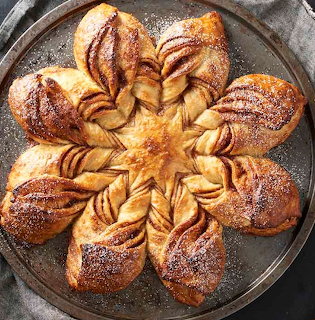Star-shaped cinnamon bread with twisted layers dusted with powdered sugar