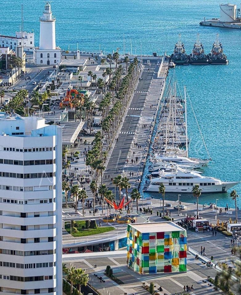 Muelle Uno waterfront promenade in Málaga, Spain with palms and harbor