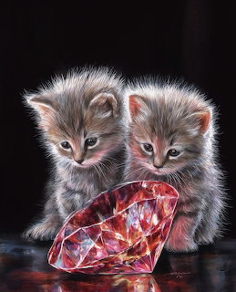 Two fluffy gray kittens beside a large red gemstone on a dark background