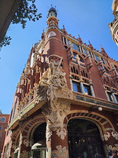 Ornate Art Nouveau building facade with sculptures and red brick in Barcelona