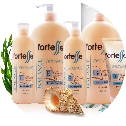 Beige hair care bottles with pump tops, seashells, a leaf, and a round mirror on a white background