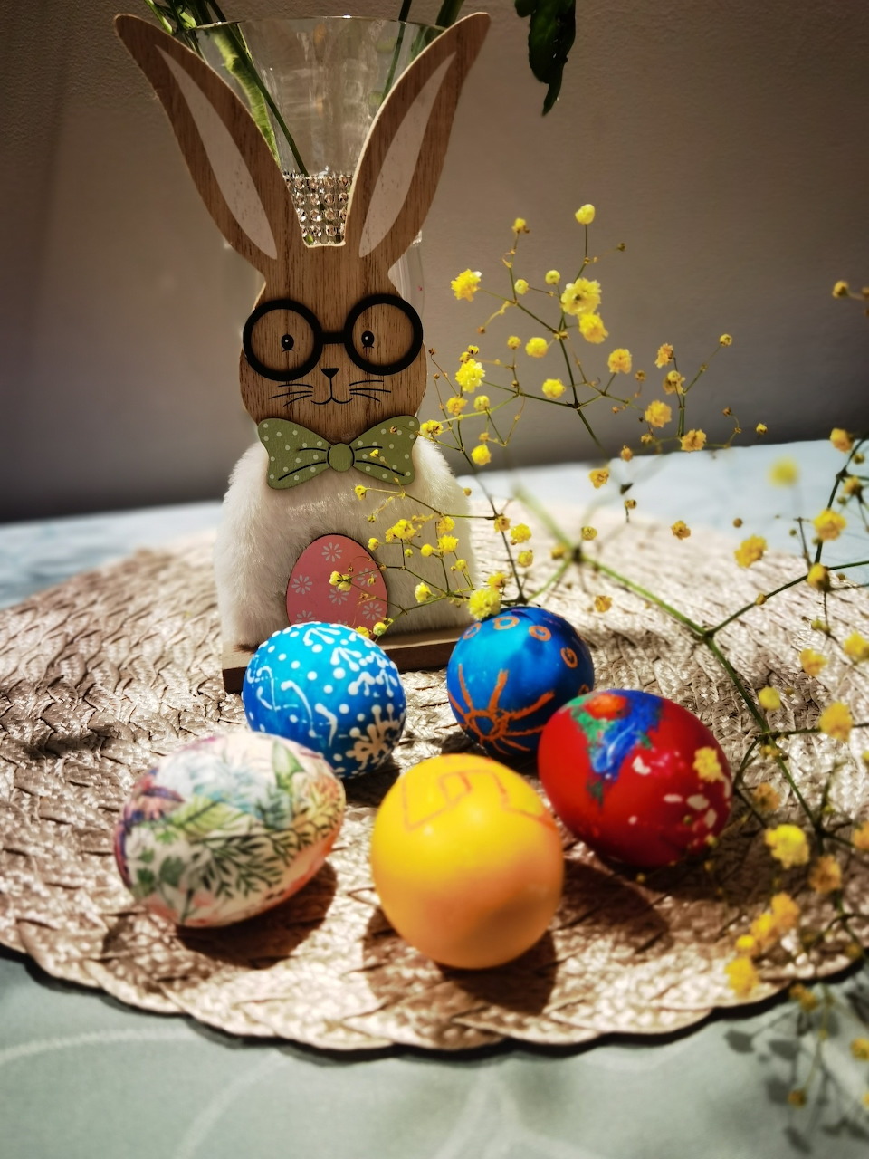 Easter bunny with basket of colorful decorated eggs in spring scene