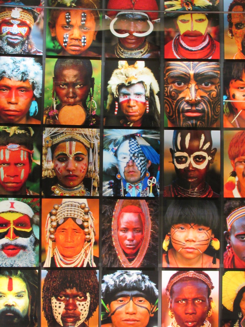 Grid of portraits showing people from indigenous cultures with colorful traditional face paint and headdresses