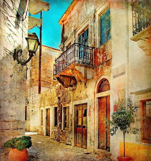 Painting of a sunny Greek village street with old stone buildings, balconies, and a street lamp