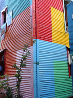 Colourful corrugated metal building walls painted in blue, red, yellow, green, and silver panels
