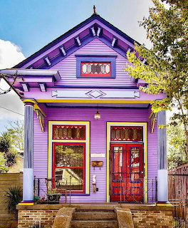 Bright purple Victorian house with red door and ornate architectural details