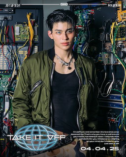 Young man in green bomber jacket posing in front of colorful wires and circuit boards