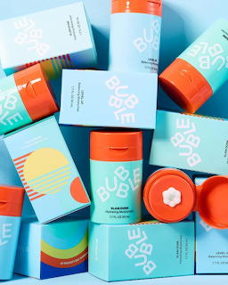 Colorful skincare products with blue and orange packaging arranged in flat lay composition