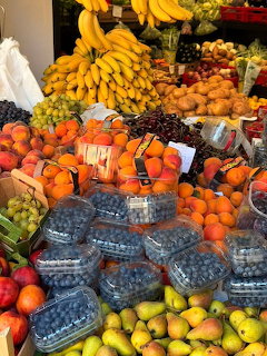 Colorful fruit market display with blueberries, oranges, banas, grapes, pears, and other fresh fruits