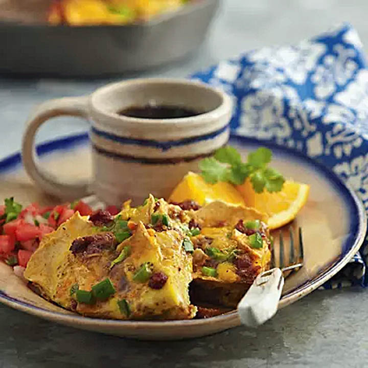 Breakfast plate with omelet, potatoes, salsa, coffee, and orange slices on a table