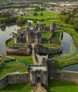 Aerial view of Caerphilly Castle, Wales, with moat, defensive walls and towers surrounded by green landscape