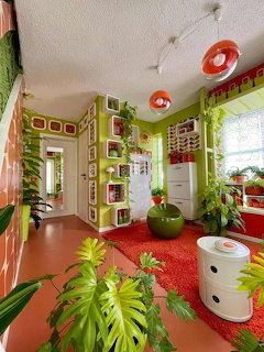 Colorful 1970s retro home interior with green walls, orange carpet, and tropical plants