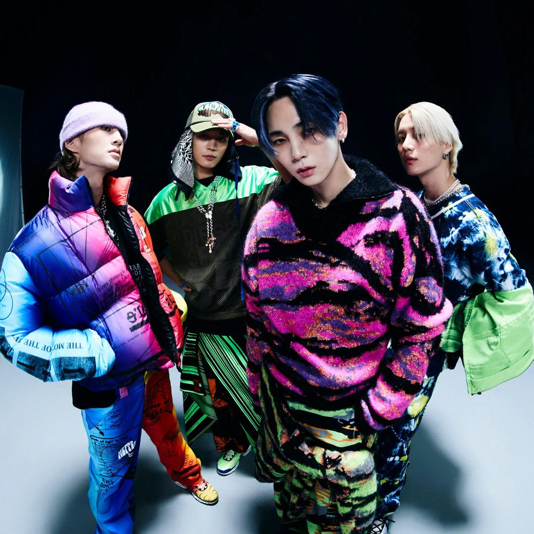 K-pop group SHINee posing in colorful streetwear outfits in studio setting