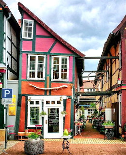 Colorful half-timbered buildings on a pedestrian street in Celle, Germany with outdoor cafe tables
