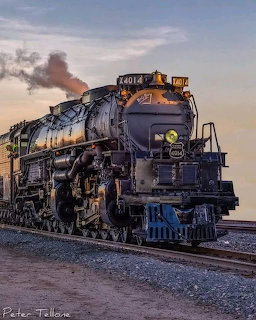 Black steam locomotive 4014 on railroad tracks, viewed from the front at dusk