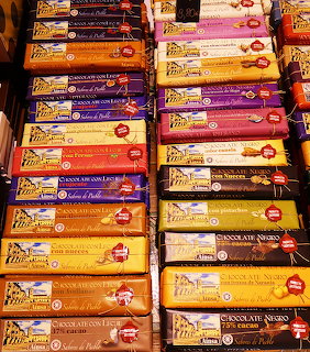 Rows of colorful Spanish chocolate bars stacked on display shelves with various flavors and packaging