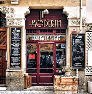 La Moderna restaurant and winery storefront in Barcelona with burgundy doors and menu boards