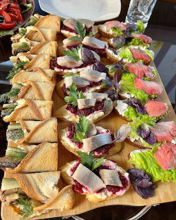 Assorted sandwiches and canapes arranged on a wooden serving board
