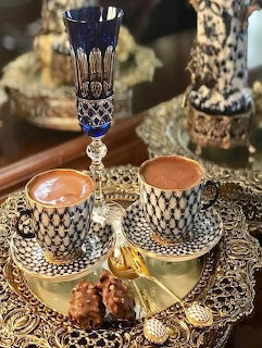 Ornate Turkish coffee set with two cups on decorated brass tray with Turkish delight