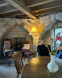 Stone-vaulted cafe interior with arched ceiling, wooden beams, and warm lighting