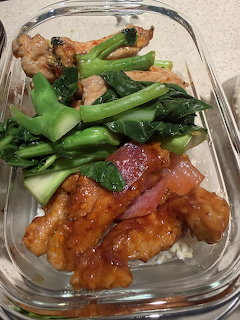 Glass lunch container with chicken teriyaki, rice, broccoli and snap peas on granite countertop