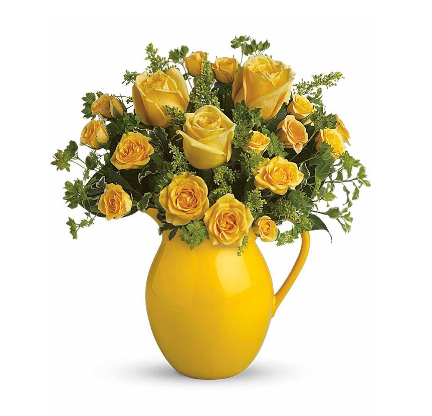Yellow roses with greenery in a yellow pitcher vase