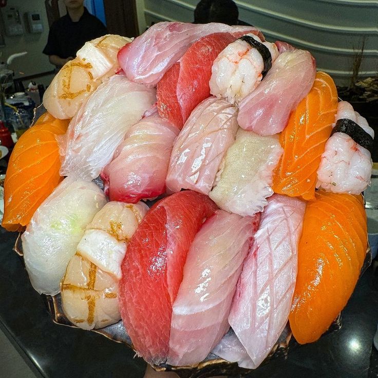 Colorful assortment of nigiri sushi and sashimi with salmon, tuna, shrimp and fish on white plate