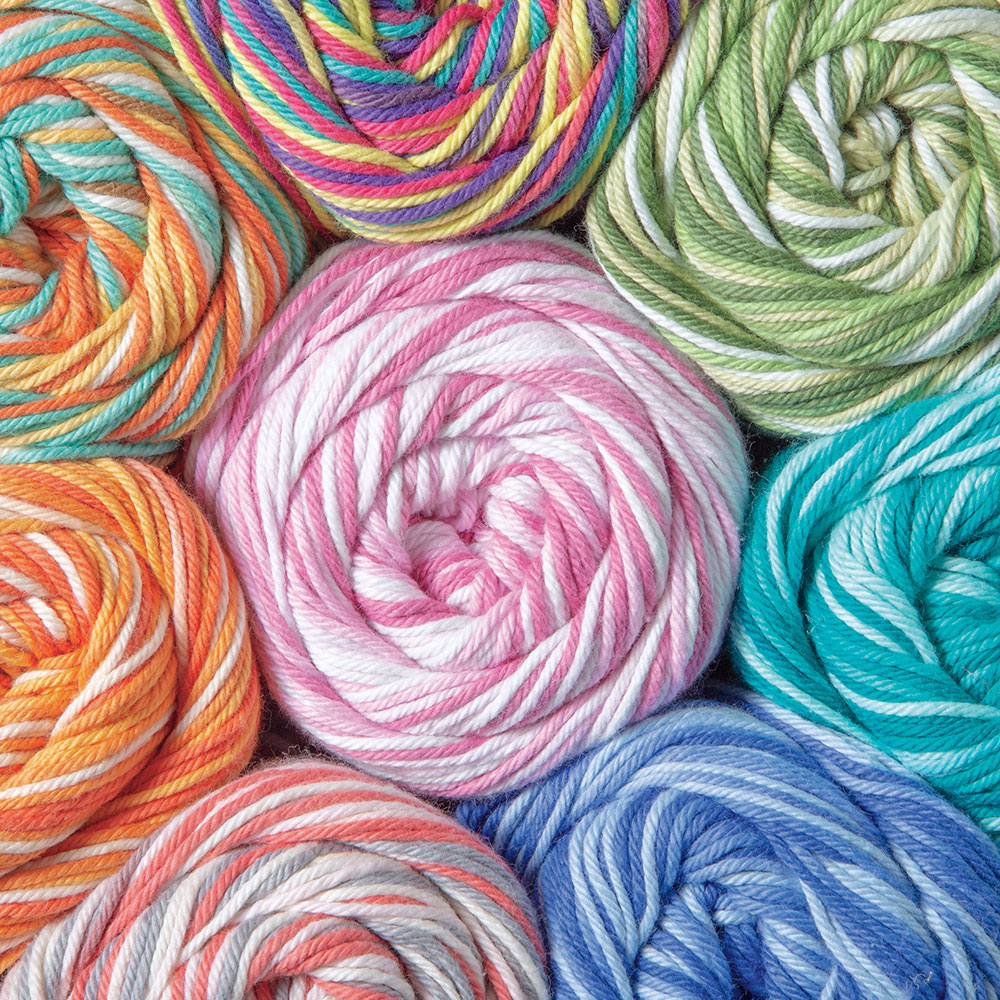 Overhead view of multicolored yarn balls with spiral wound thread patterns in pink, blue, orange, green, and purple