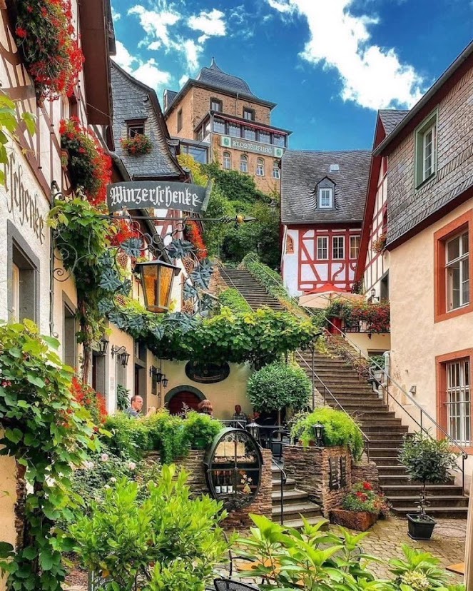 Historic village street in Beilstein, Germany with steps, timber-framed houses, vines, and flowers