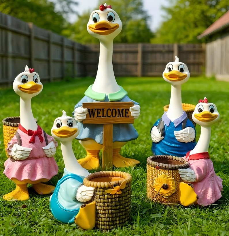 Four duck garden figurines with a welcome sign and baskets in a grassy backyard