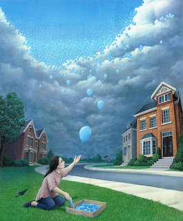 Boy releasing blue balloon on street under surreal cloudy sky between brick houses