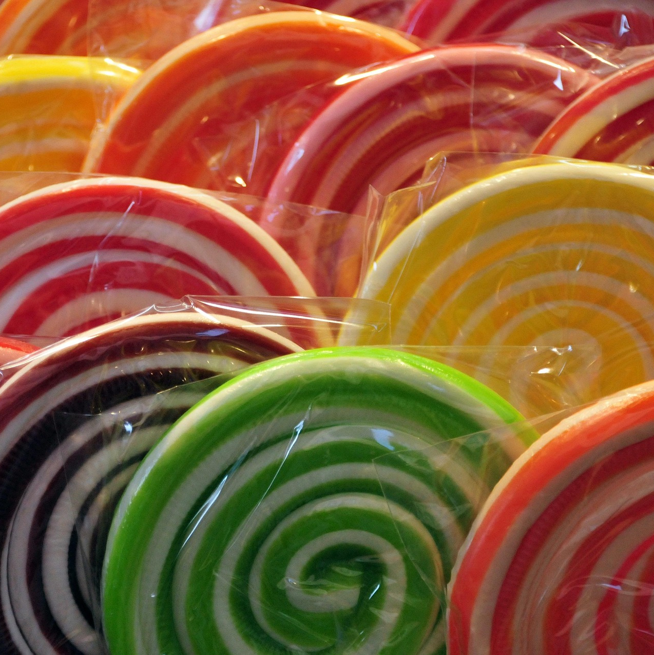 Close-up of colorful swirled lollipops in clear plastic wrappers