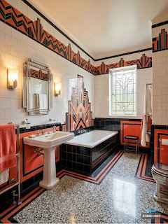 Art Deco bathroom with geometric tiles, coral vanity, black bathtub, and decorative wall borders