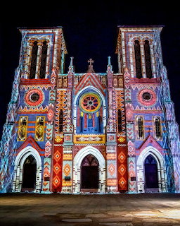San Fernando Cathedral illuminated with colorful projected lights against night sky