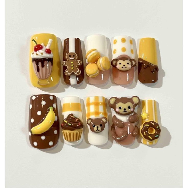 Set of press-on nails with monkey and dessert designs in brown, yellow, and white