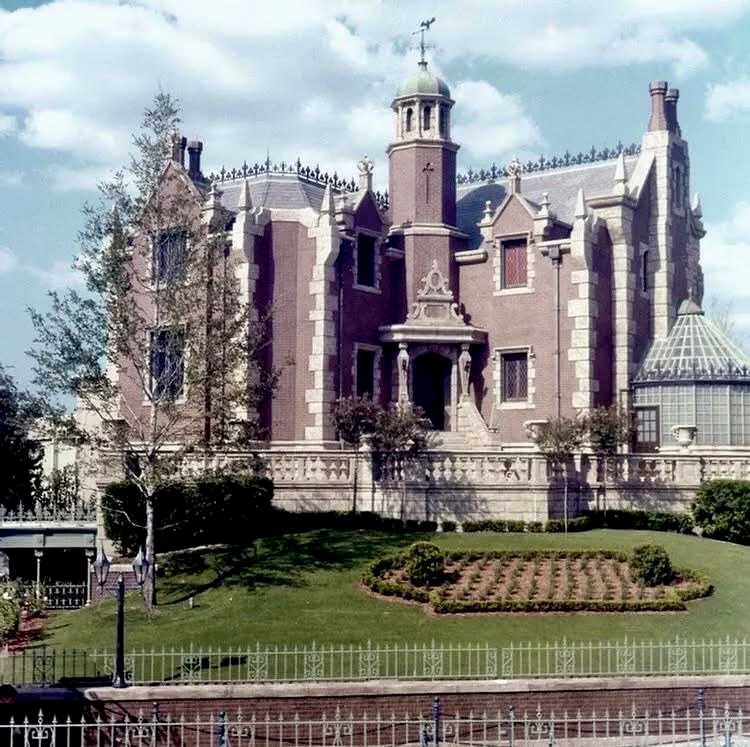 Gothic Victorian Haunted Mansion building at Magic Kingdom with towers and green lawn in foreground