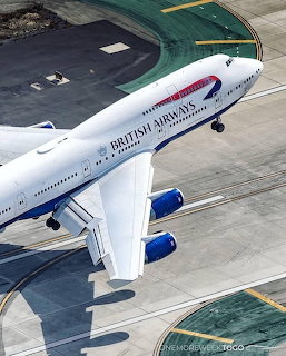 Overhead view of British Airways 747 aircraft on airport tarmac with runway markings
