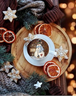 Hot chocolate with snowman marshmallow, Christmas cookies, dried oranges, and pine decoration on wooden board