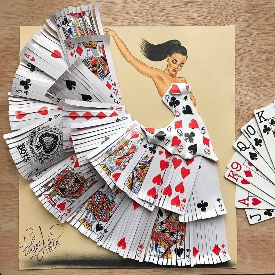 Woman wearing dress made of playing cards with hearts, diamonds, clubs and spades spreading outward