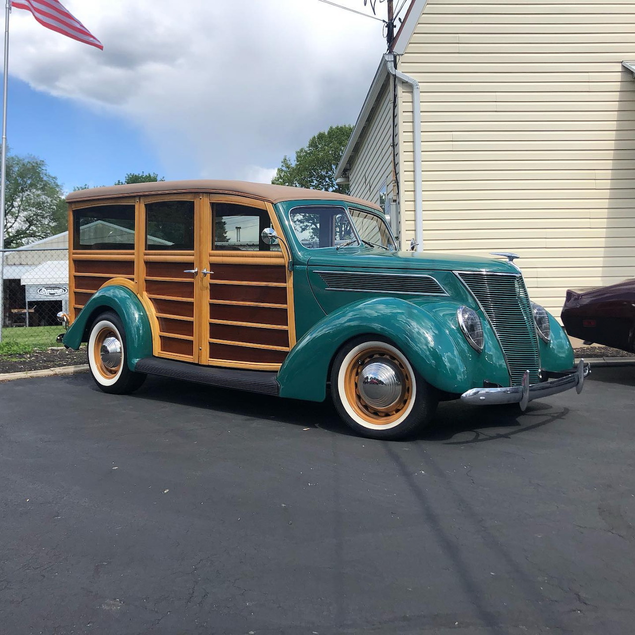 Vintage teal woody station wagon with wood side panels parked on pavement