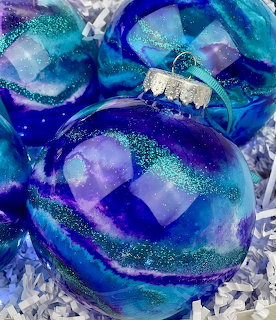Blue and purple glittery Christmas ornaments with decorative ribbons