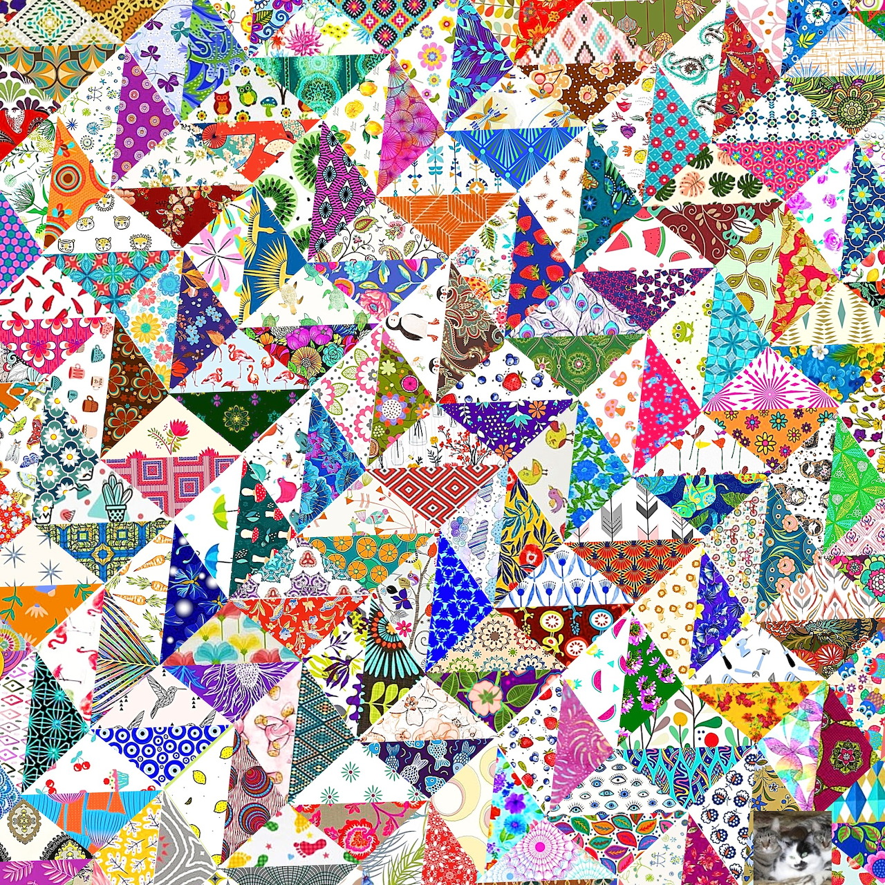Colorful patchwork quilt with triangular fabric pieces in various patterns and bright colors