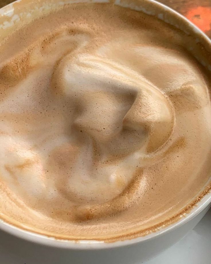 Overhead view of whipped dalgona coffee with thick creamy foam in white cup
