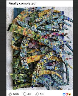 Colorful mosaic artwork with swirling patterns made from small glass and tile pieces in various colors